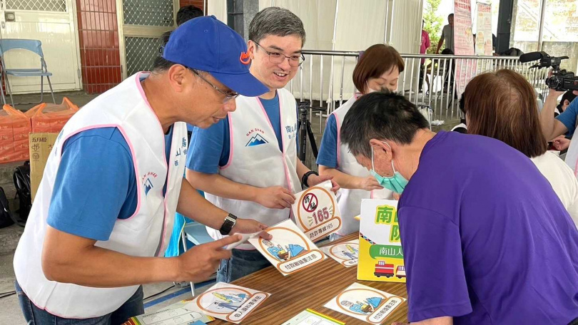 南山人壽啟動原鄉醫療關懷列車，董事長尹崇堯（中）、總經理范文偉（左）向參與活動的部落民眾宣導防詐騙意。（圖／南山人壽提供）