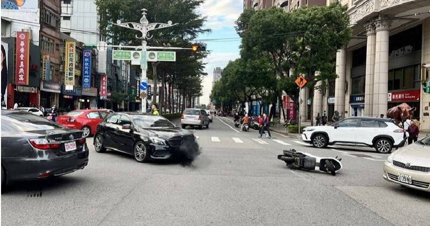 桃園員警為閃避左轉的賓士車，不慎急煞時連人帶車飛摔出去，滑行數公尺至路口中央才停下。（圖／翻攝畫面）