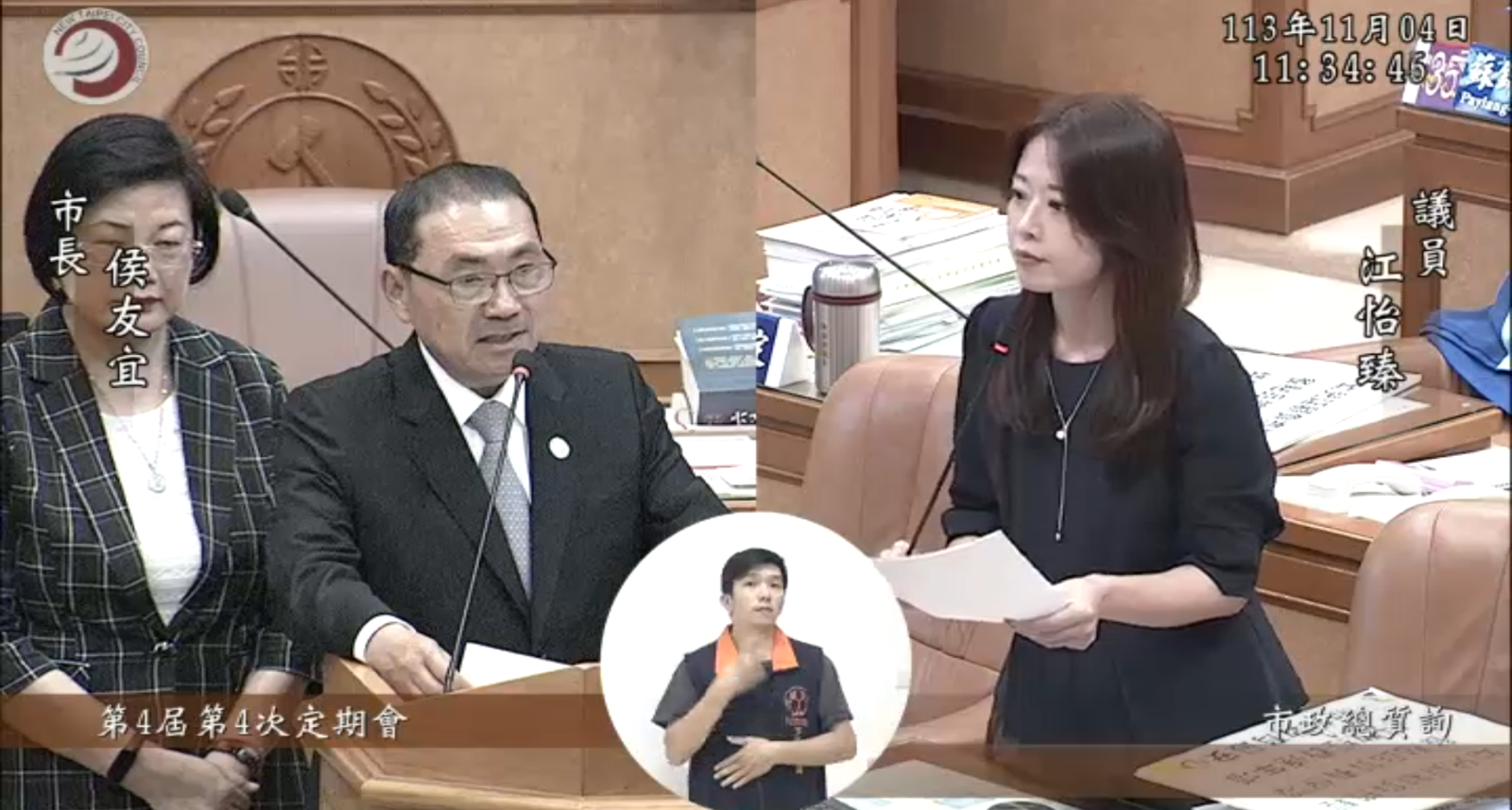 新北市議員江怡臻（右）質詢新北市長侯友宜，盼公立幼兒園的每日餐點費調高，並降低課後延托費用。（翻攝新北市議會直播）