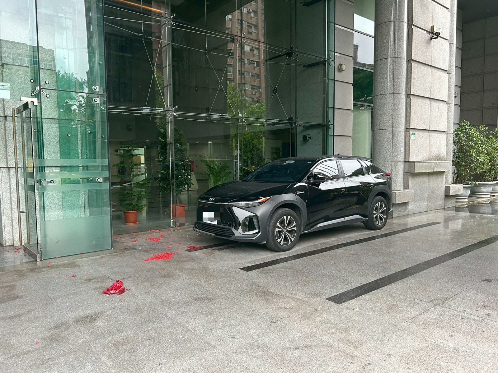 交通部門口遺留大量鞭炮紙屑，一旁車輛險遭波及。（翻攝畫面）